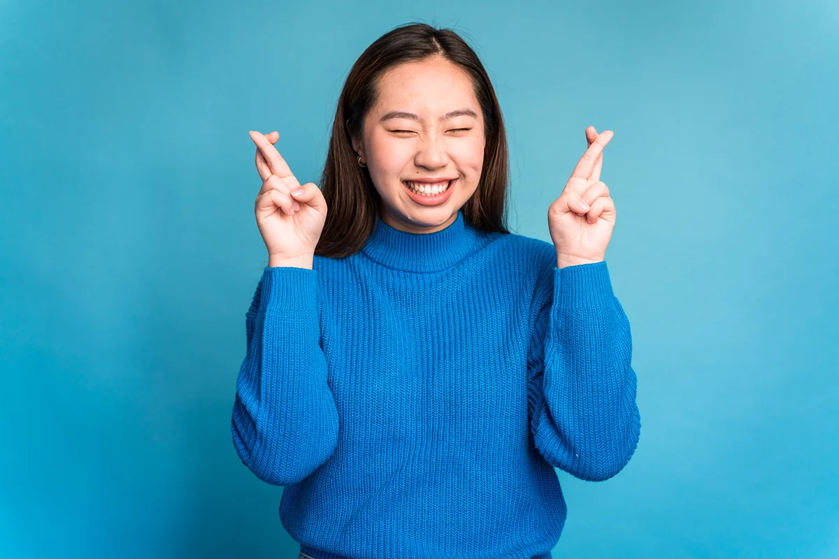 Cheerful woman crossing fingers