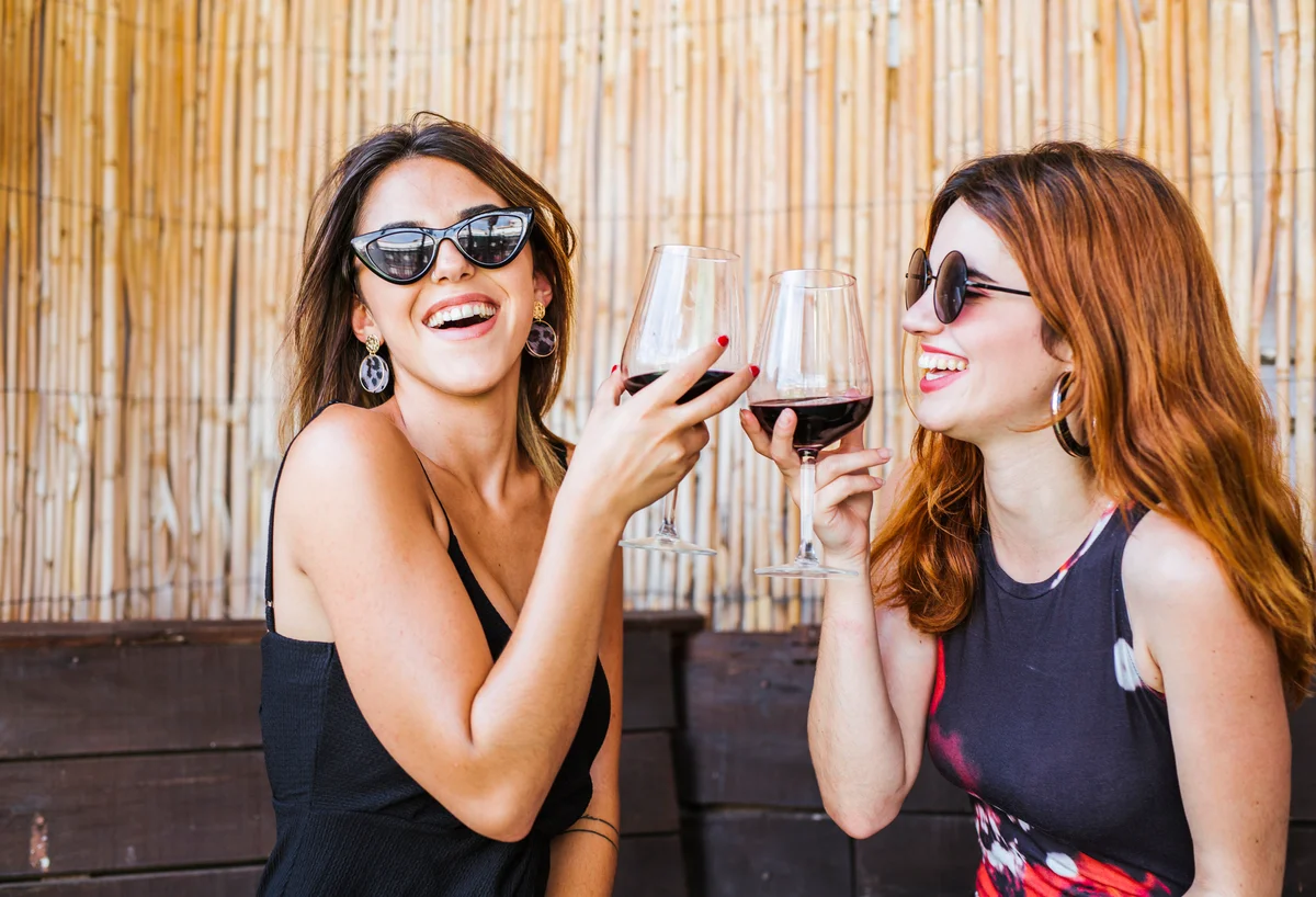 two women drinking red wine
