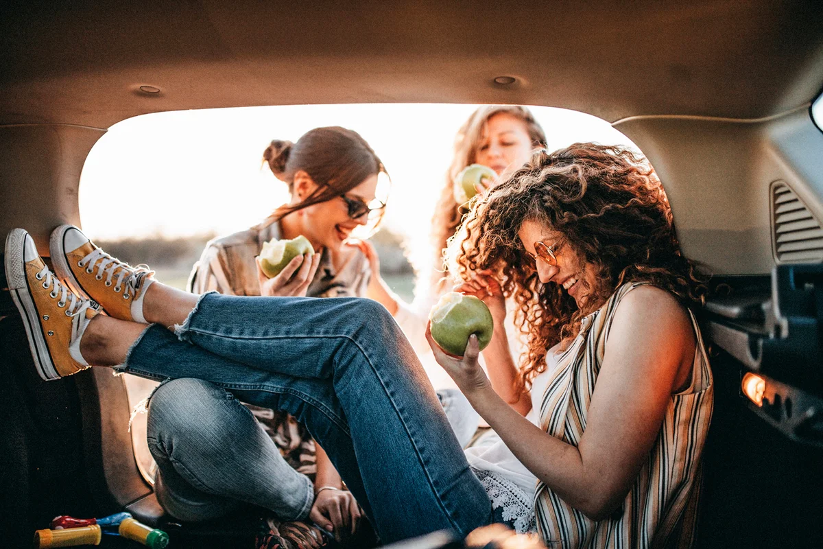 Young friends having fun in trunk of car