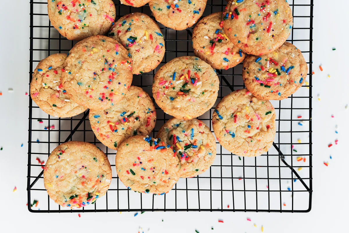Homemade cookies with colorful sprinkle on baking rack