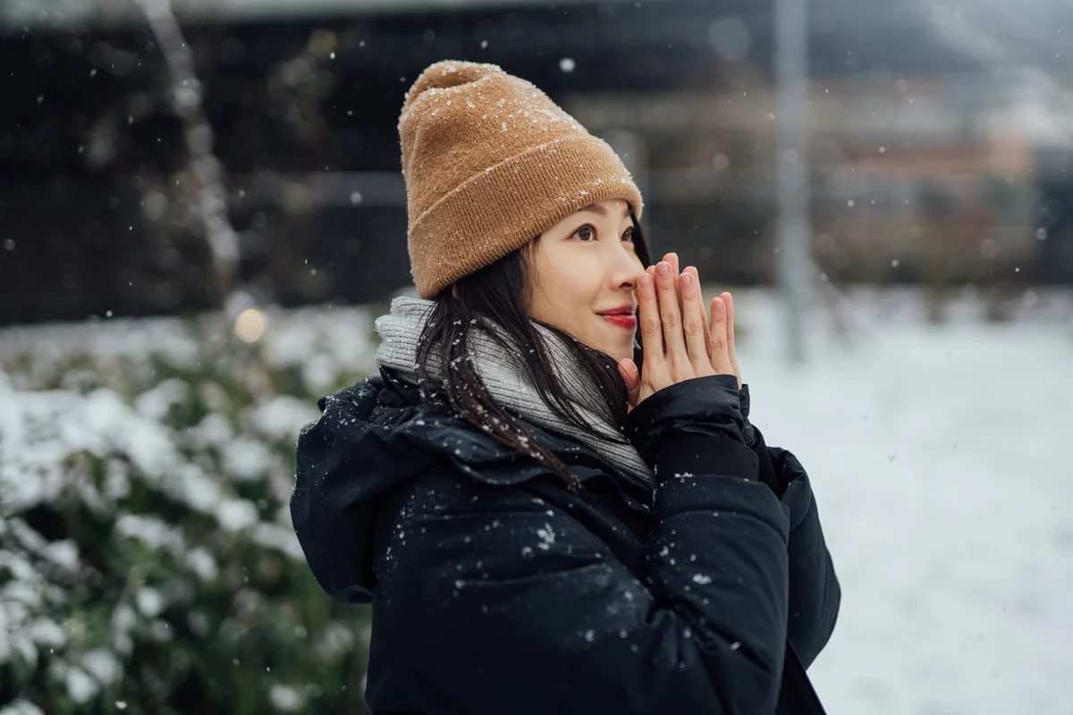 Woman Warming Her Hands In The Snow