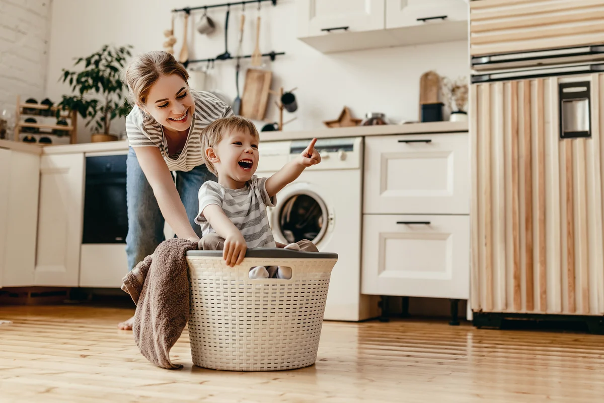 Mother and son playing with the laundry basket