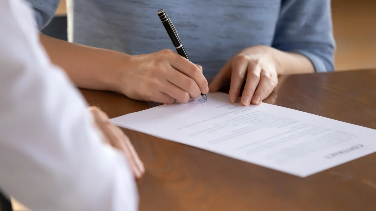 woman signing paperwork
