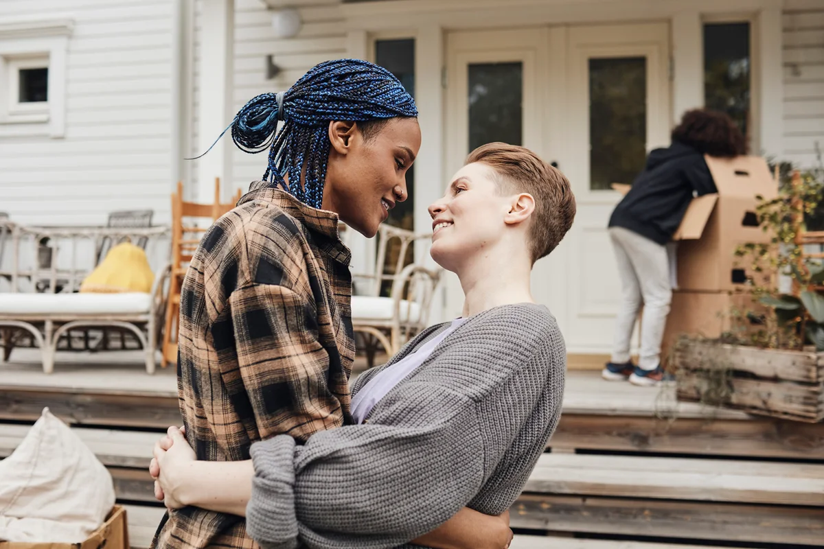 Side view of romantic couple embracing each other outside new house
