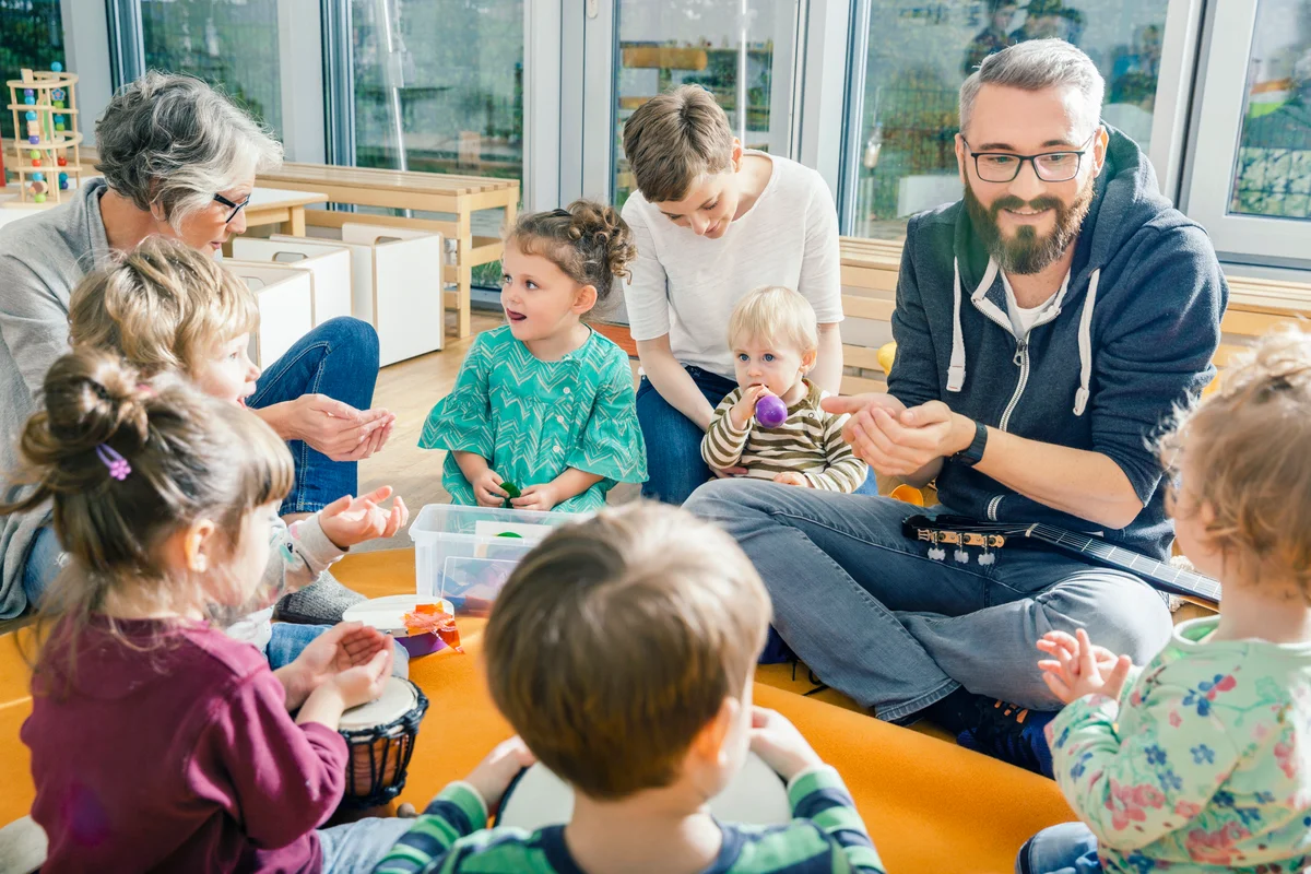 Children and teachers playing and making music in kindergarten