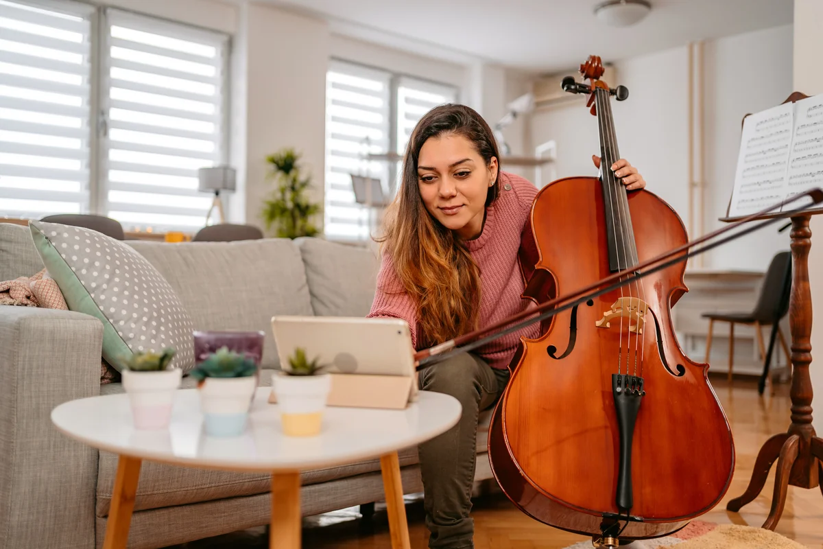 Young Woman Watching A Tutorial On How To Play Cello
