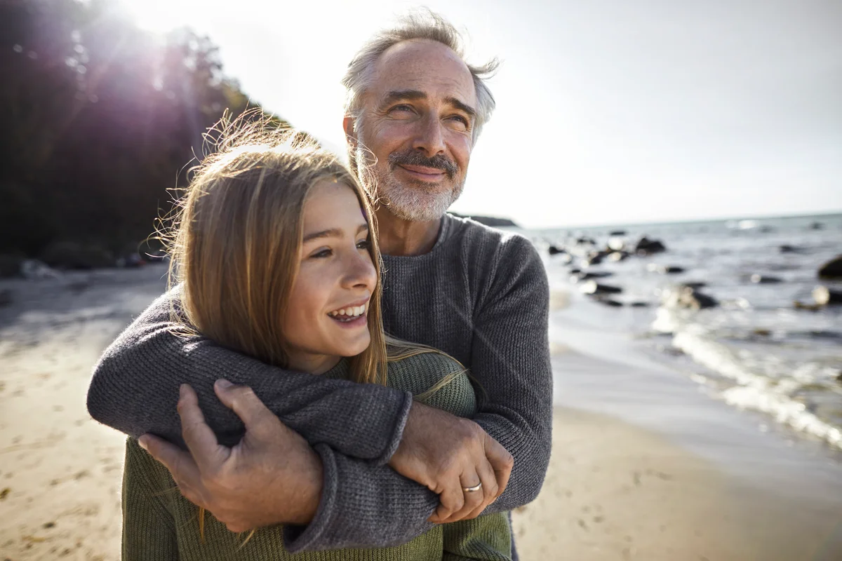 father and daughter hugging on beach