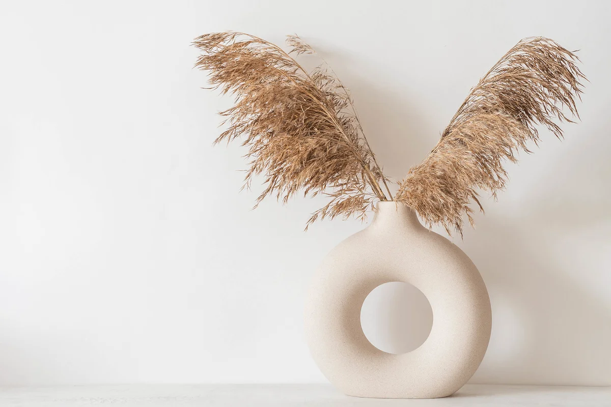 Dry autumn reed branches in round ceramic vase