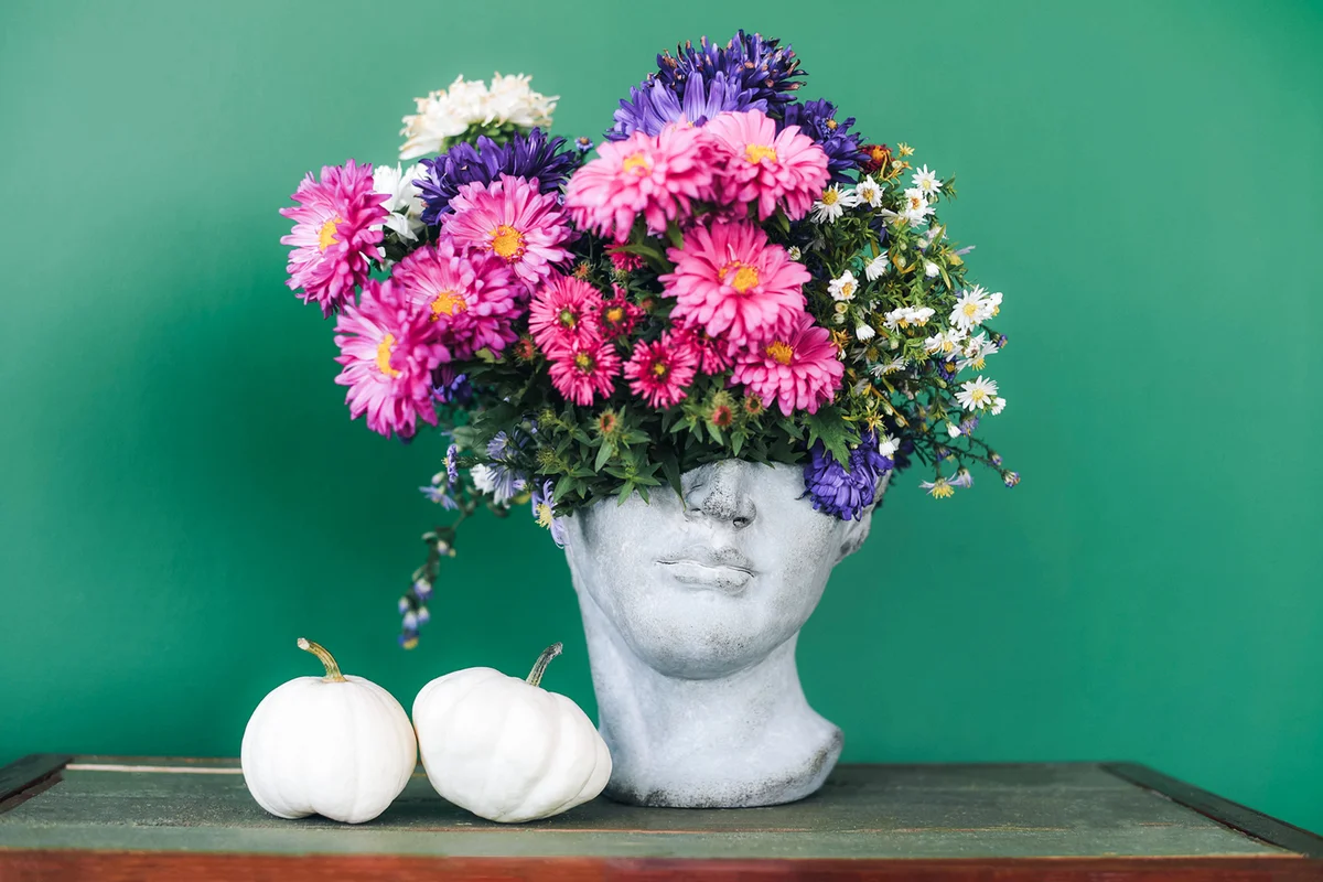 Head-shaped vase with a bouquet of flowers
