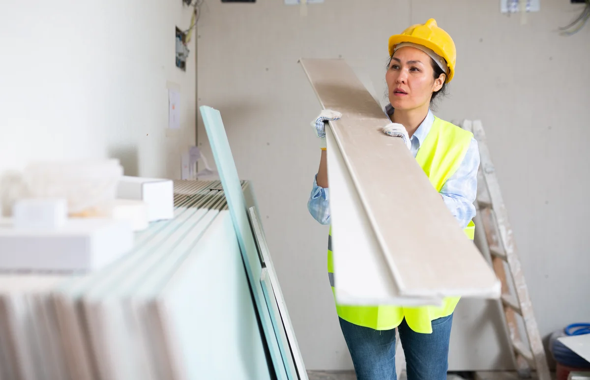 woman lifting drywall