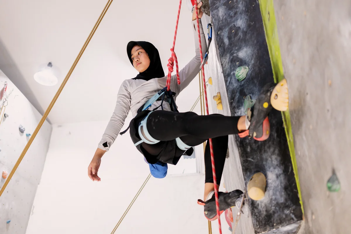 teen doing a climbing wall