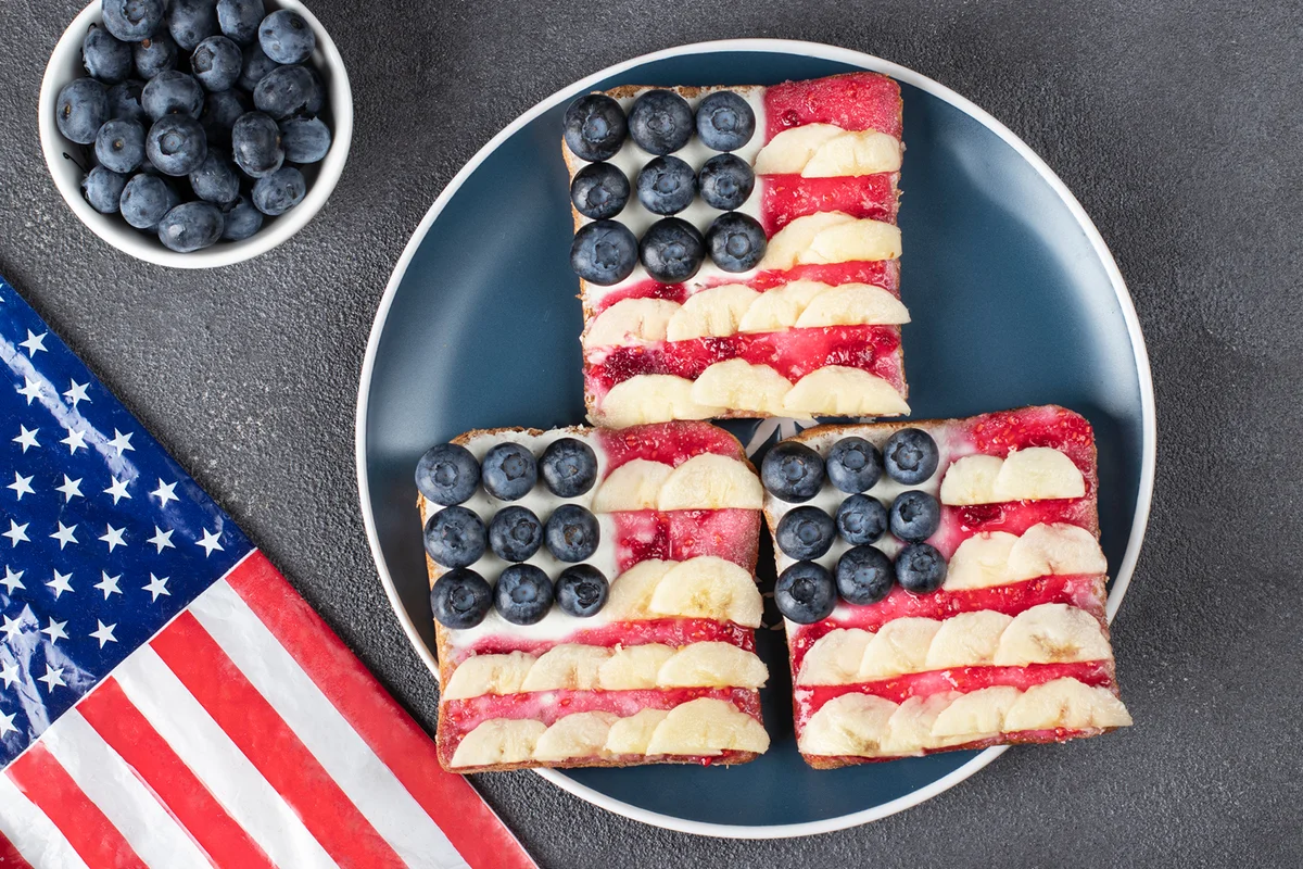 American flag sandwiches with blueberry, banana and berry jam on toast bread on blue plate