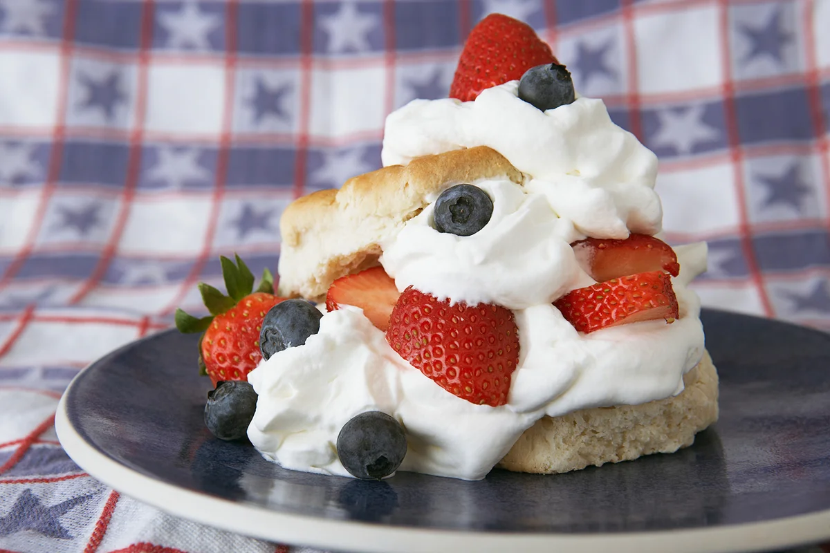 Strawberries, blueberries and whipped cream on a scone
