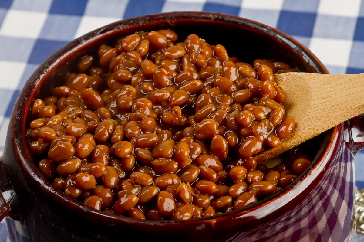 Crock pot full of baked beans on blue gingham