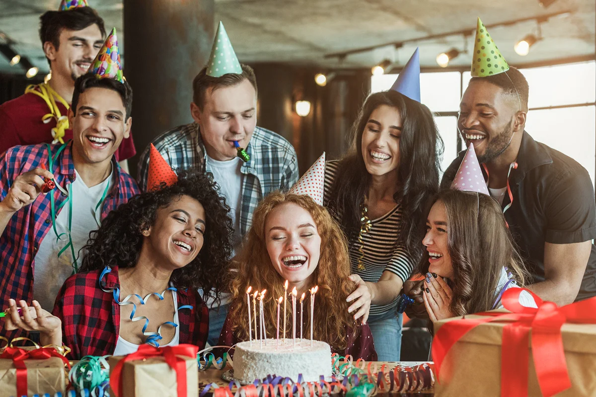 Friends presenting birthday cake to girl