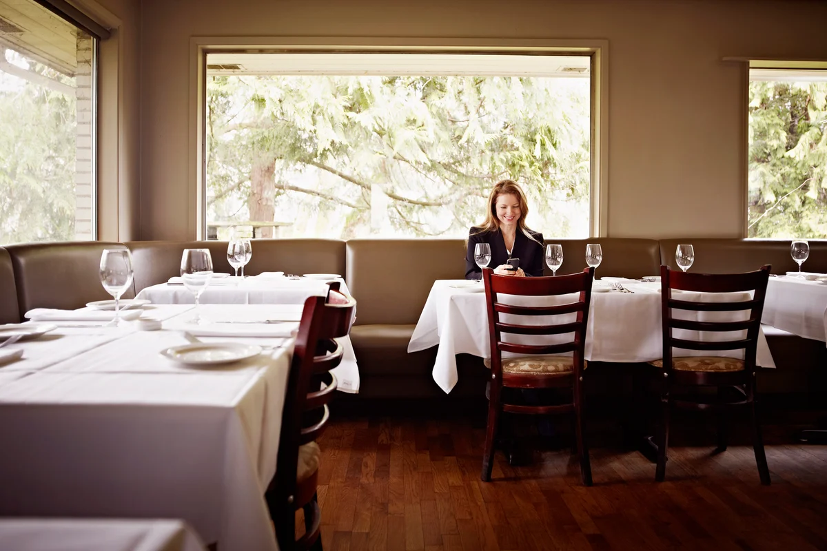 Woman sitting in empty restaurant smiling