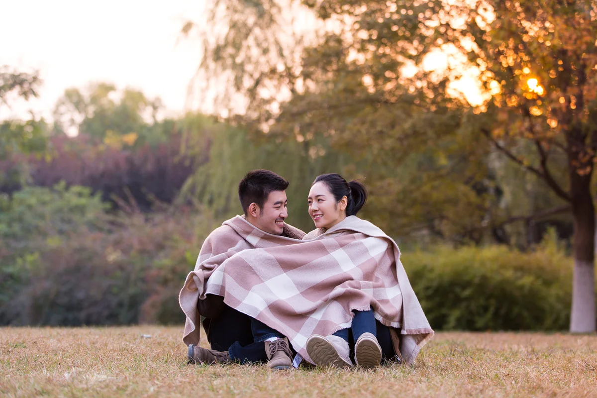 couple sitting in love around the same shawl