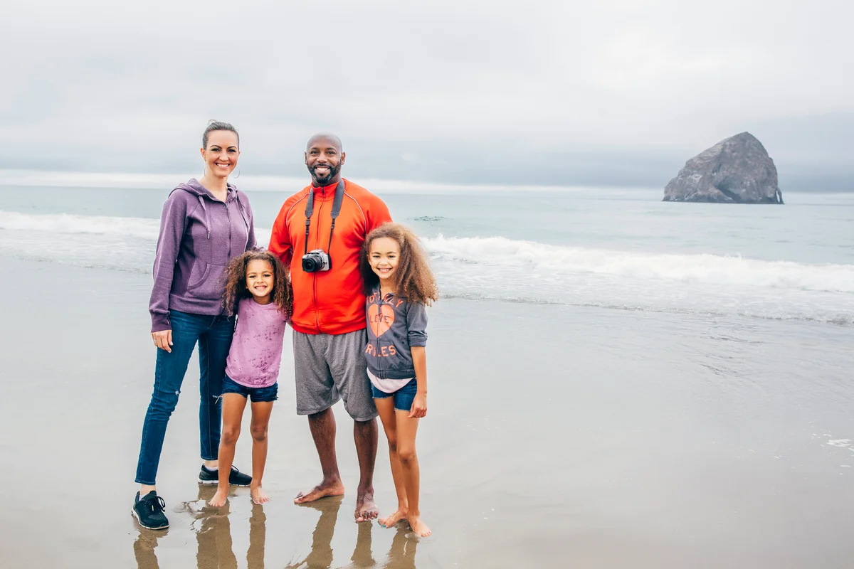 Family smiling on the beach on a foggy day