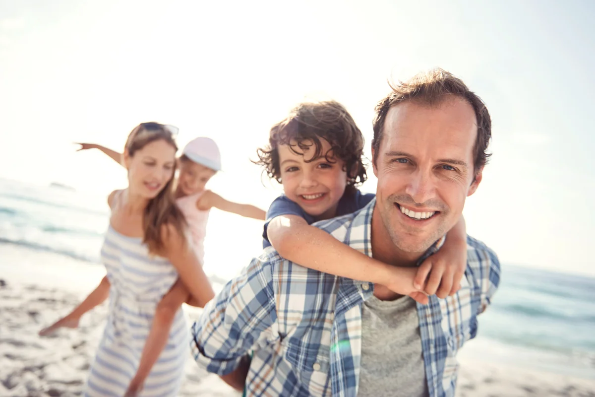Happy young family having fun at the beach