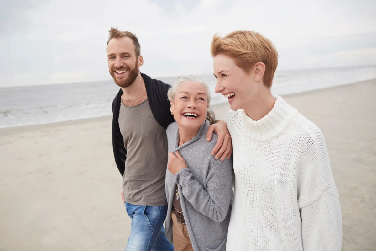 Happy couple with senior mother on the beach
