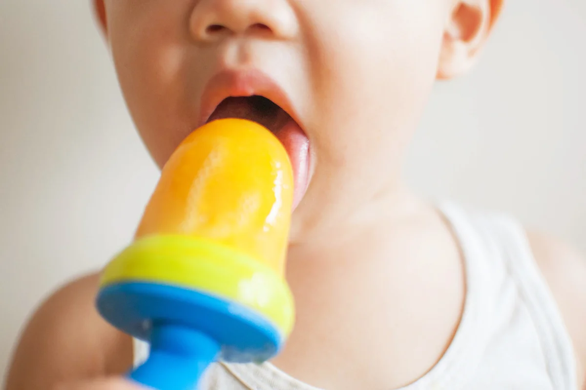 Toddler eating a homemade mango ice pop