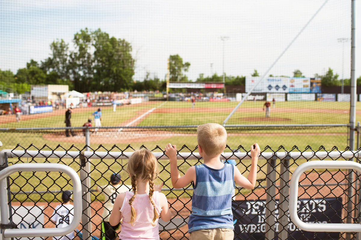 Siblings watching baseball match