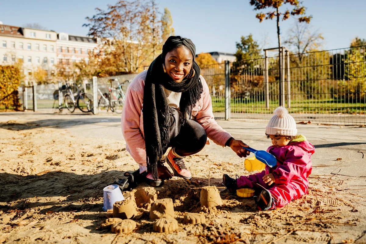Mother Playing With Toddler In Sand Pit
