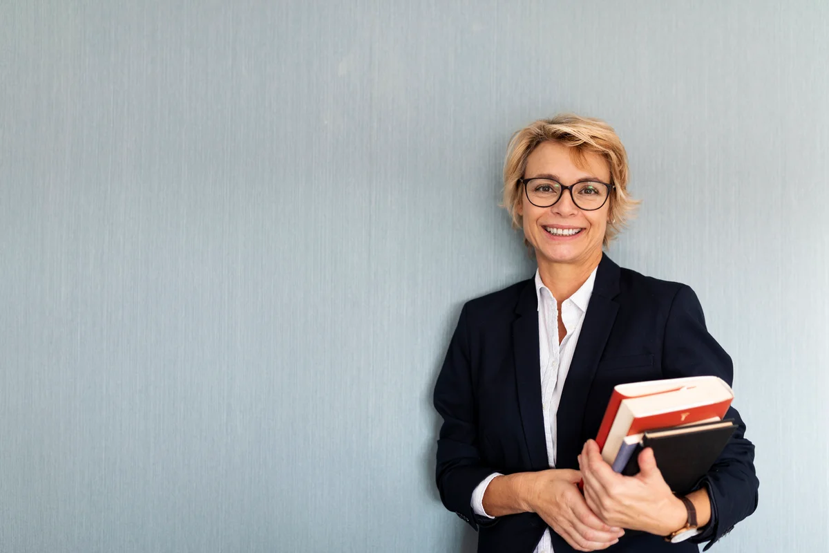 woman holding a stack of books