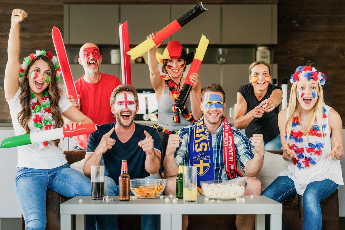 Celebrating soccer fans watching football world cup on tv at home