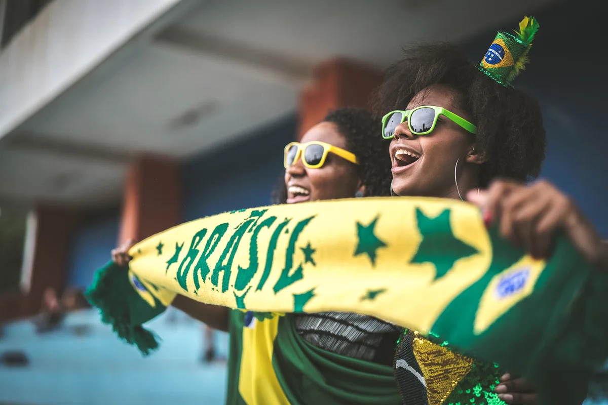 Brazilian fan friends celebrating in a soccer game