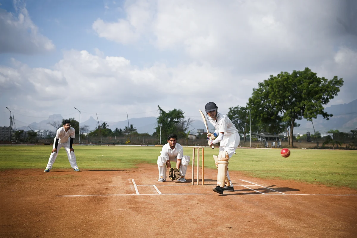 A front view of a focused batsman in action taking long shot