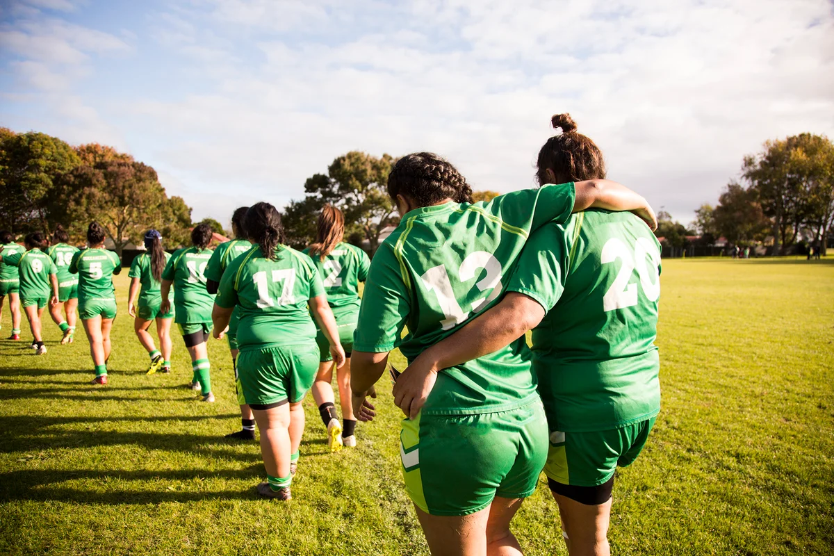 Line of female rugby players walking away from camera