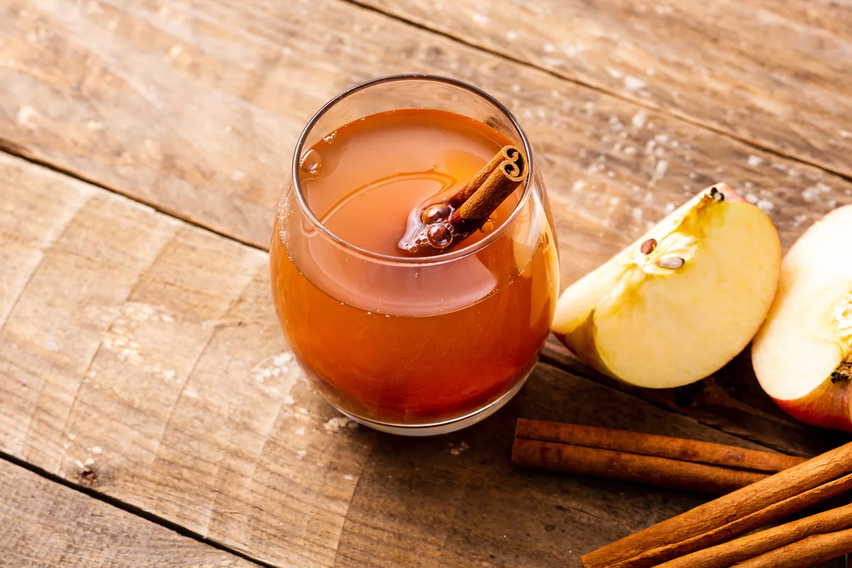 Hot cup of apple cinnamon tea on wooden table