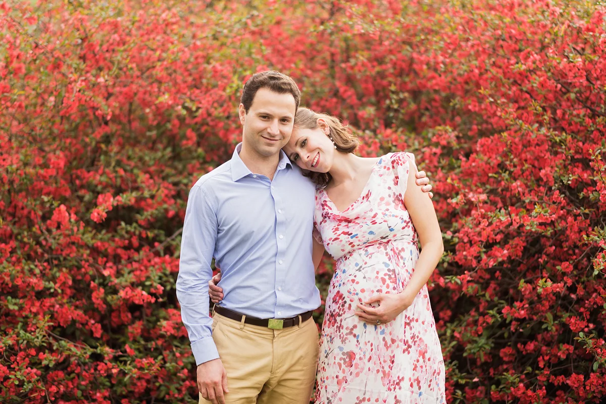 Pregnant couple hugging outdoors