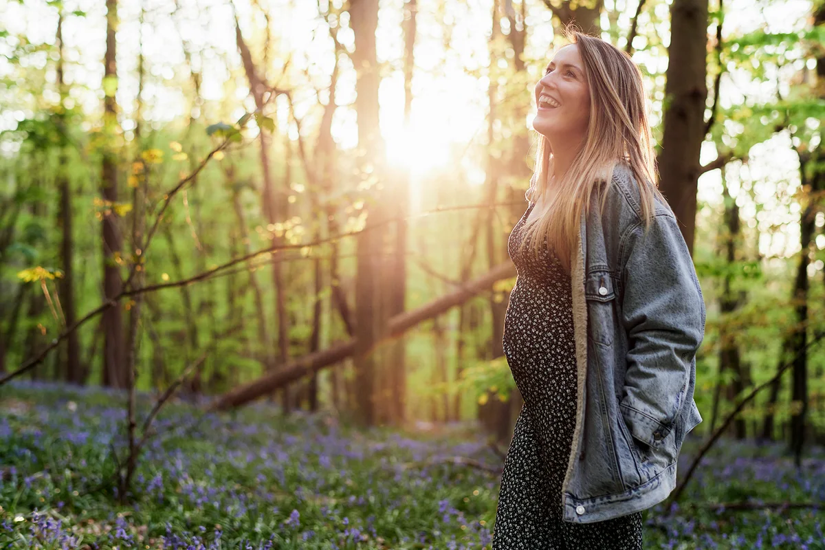 Portrait of pregnant woman in woodland -