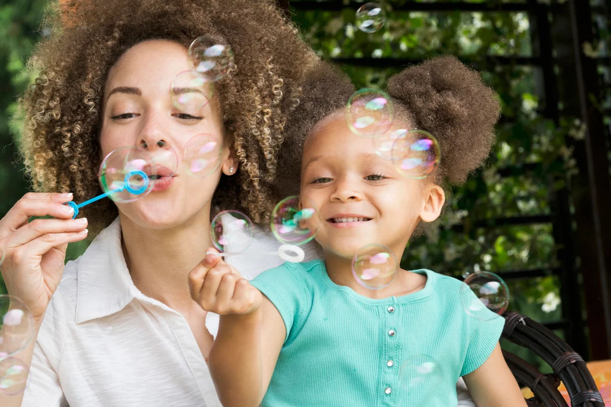 Mother and daughter blowing bubbles