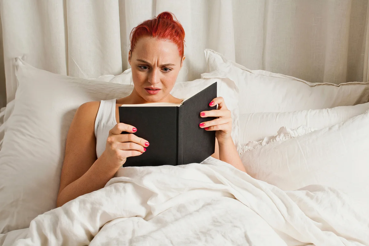 Woman reading book in bed
