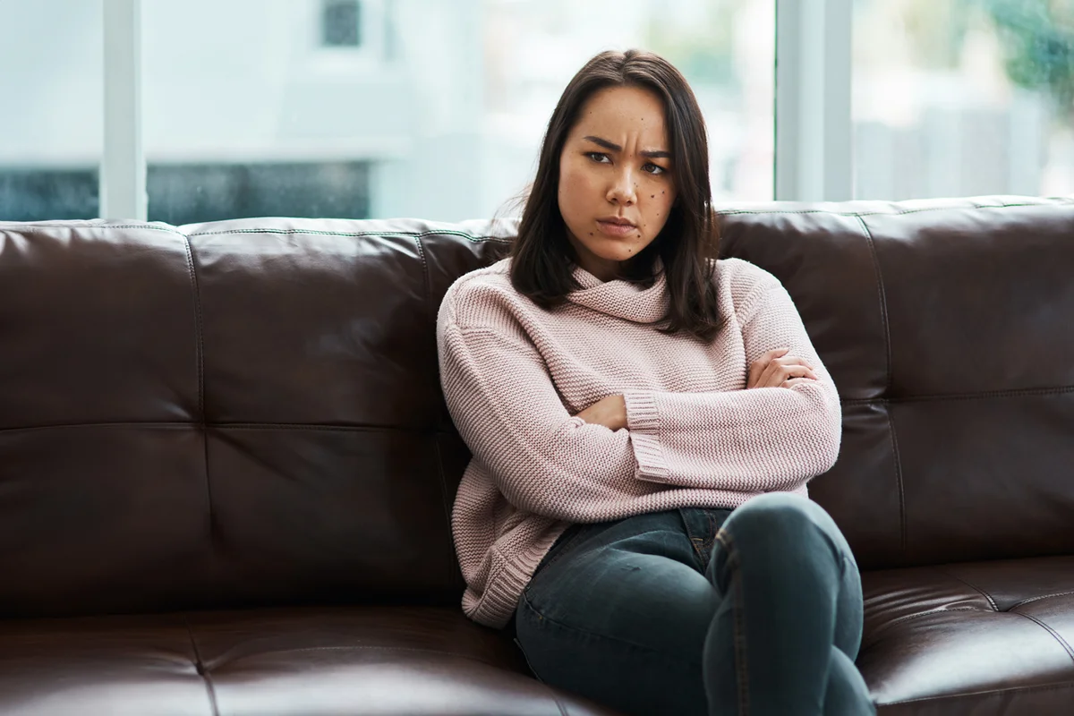 Grumpy woman on sofa