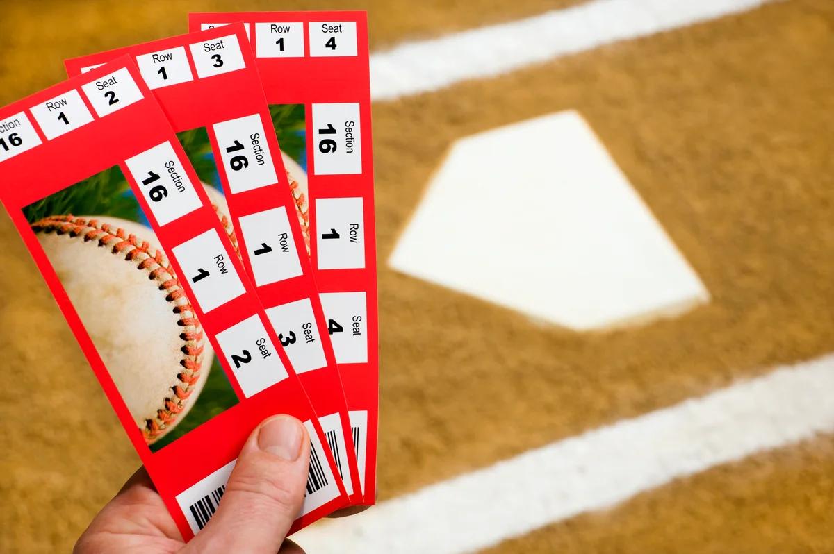 hand holding baseball game tickets