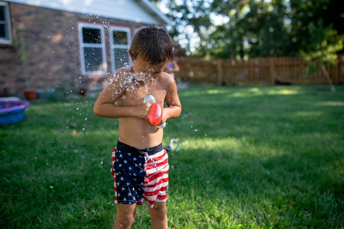 Little boy playing with water balloons