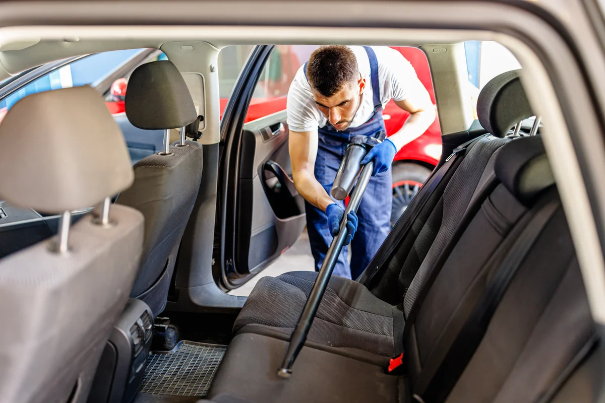 man vacuuming car
