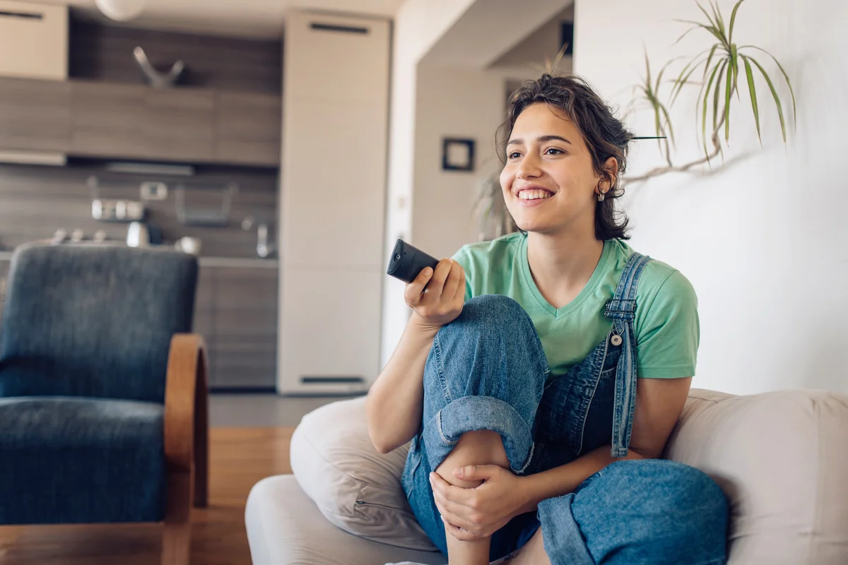 Young woman enjoying her favorite TV show at home