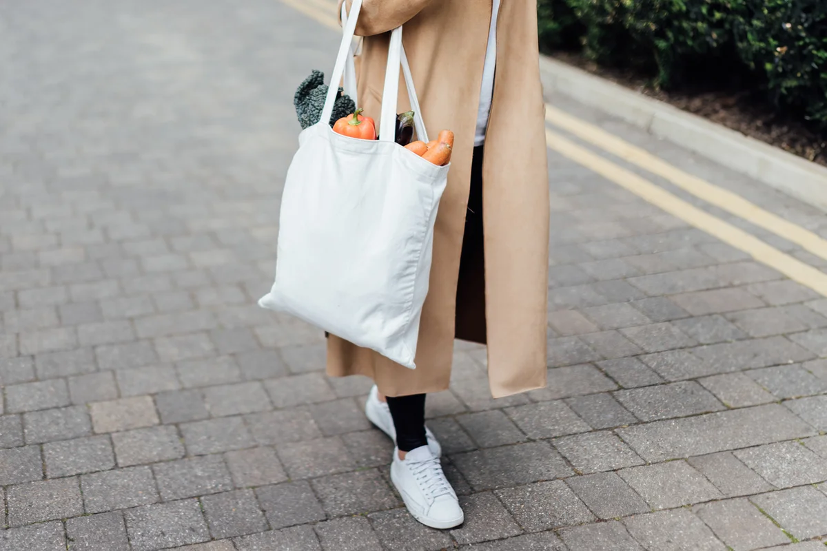Responsible shopper using reusable shopping bag for groceries