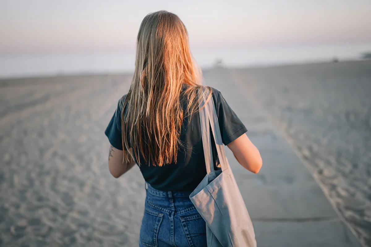 Woman walking on beach during sunset