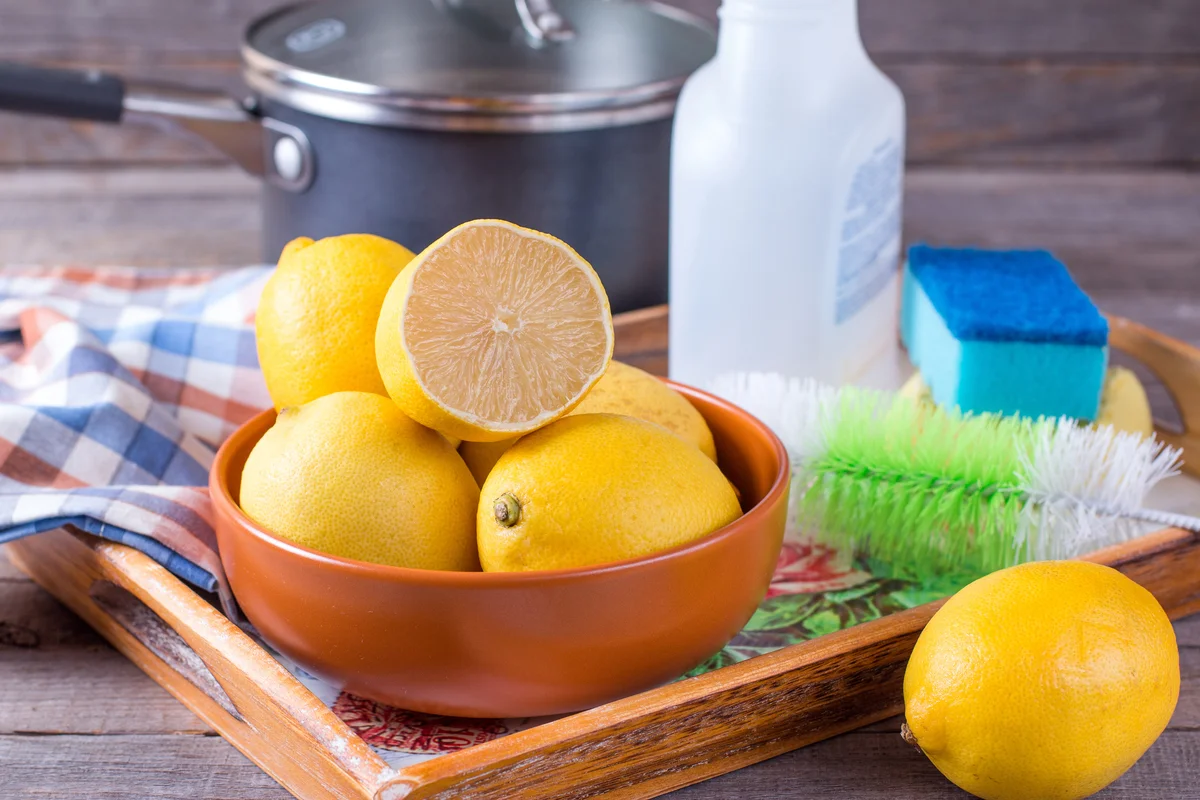 a bowl of lemons and cleaning supplies
