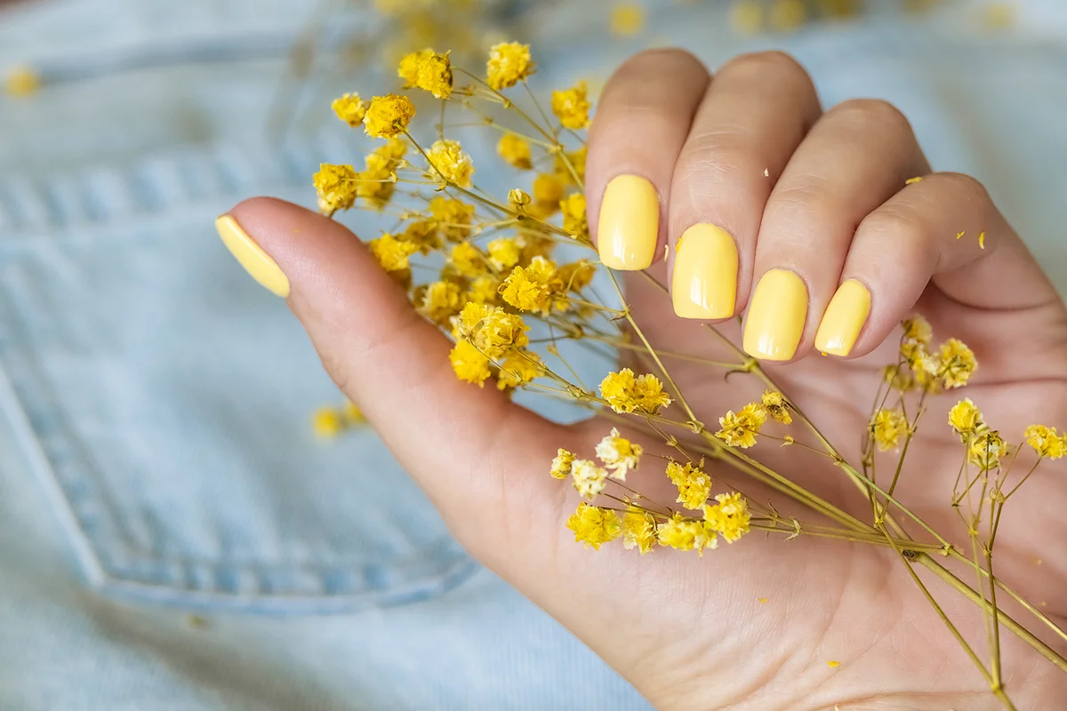 Woman's nails with yellow manicure
