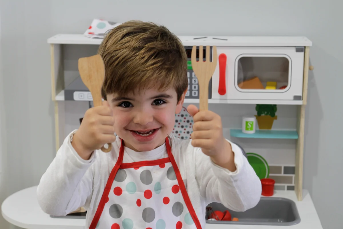 child with toy kitchen