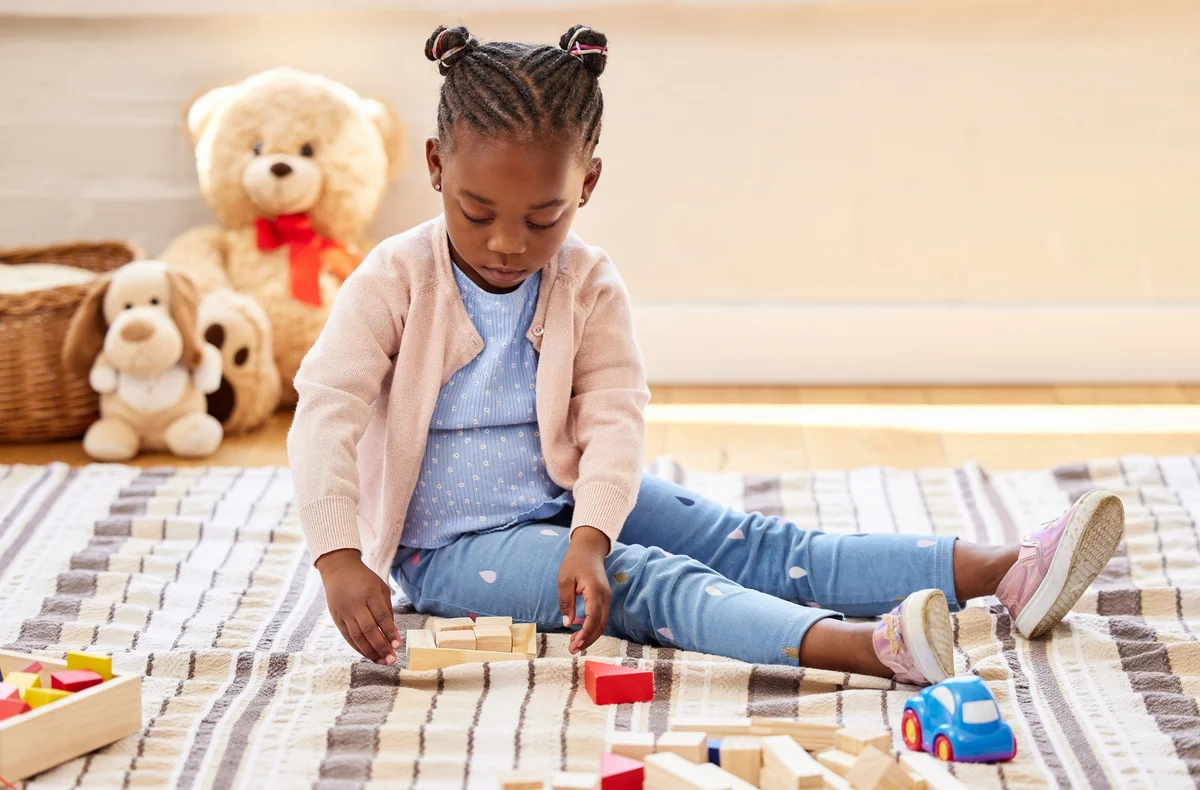 girl playing on blanket