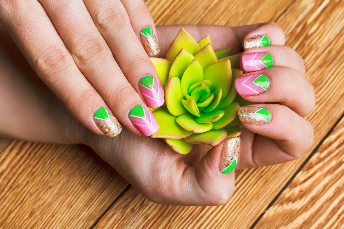 Nail art with bright gold, pink and green chevron pattern