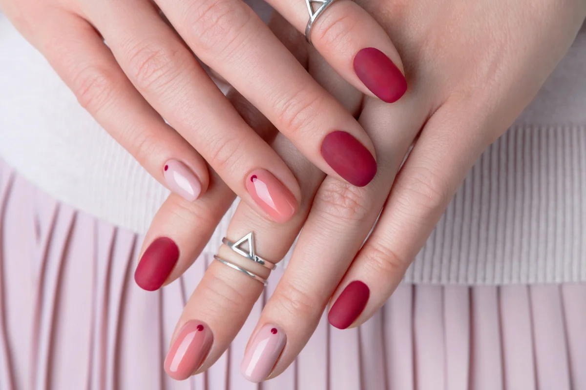 Young woman with minimal pink and red summer manicure design
